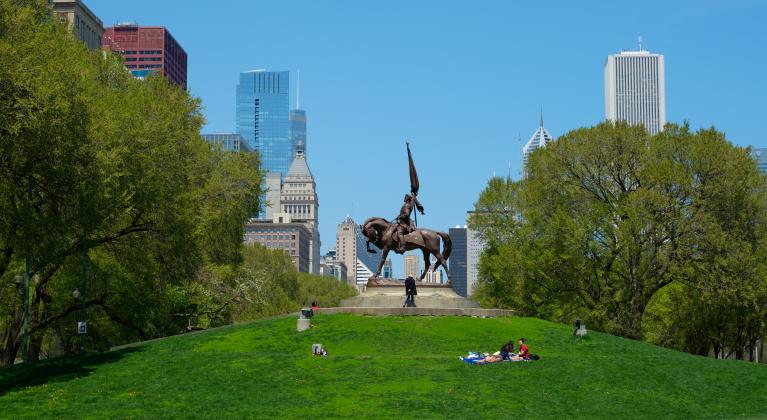 people lay on green grass beside statue